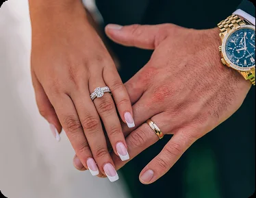 An engaged couple holding hands on a yacht